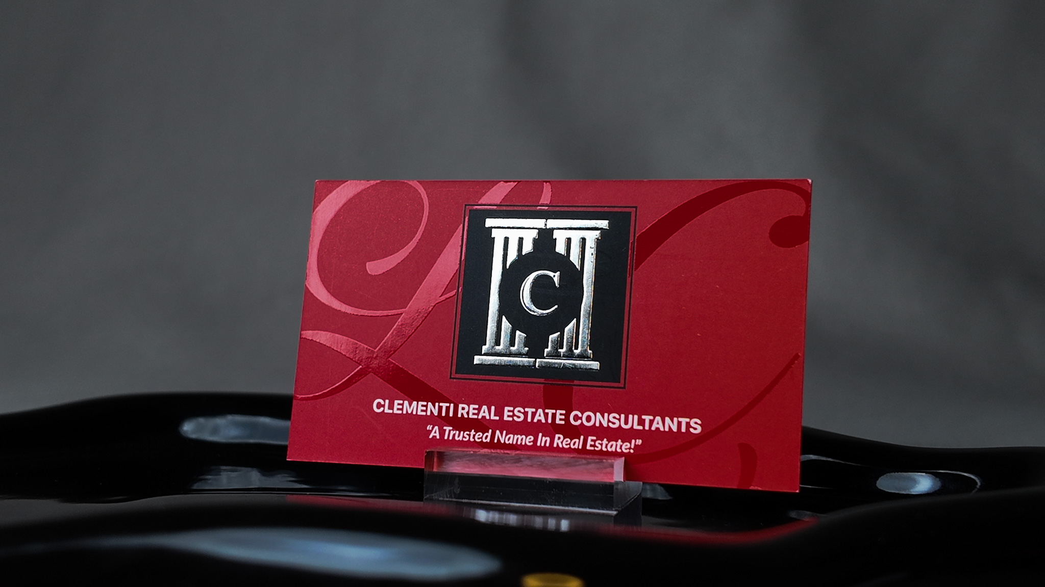 real estate business card for Clementi Real Estate Consultants showing raised logo detail